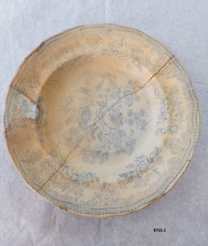 Dinner plate with blue floral design featuring two pheasants. Has a large crack going from one side to the other.