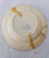 Back of cream coloured dinner plate with a large crack across entire width.