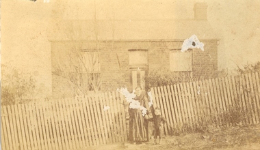Woman and child in front of a house