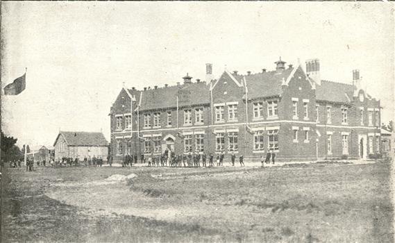 students outside a double storey brick building