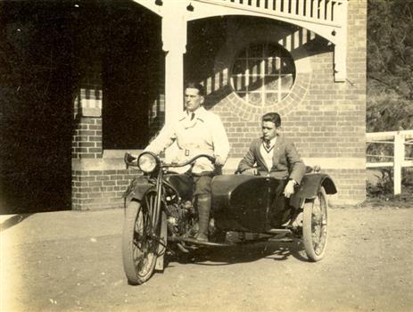 Two men on a motorbike with side car