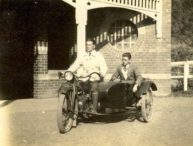 Two men on a motorbike with side car