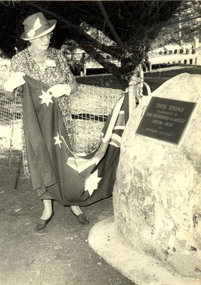 A woman removed a flag from a large rock