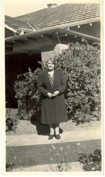 A woman in front of a house