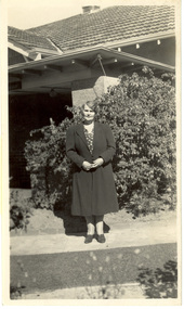 A woman in front of a house