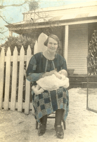Seated woman holding a baby