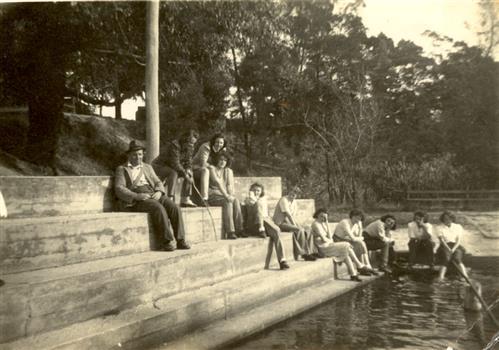 Swimming pool with people sitting around it. 