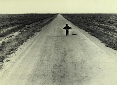 A child in costume on a deserted road