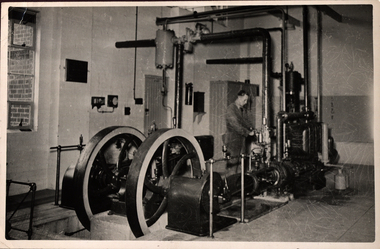 A man stands working on a steam engine
