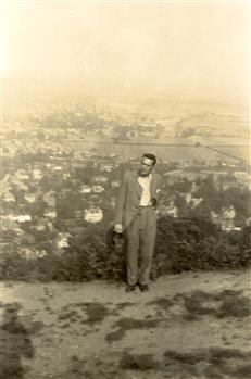 A man on a hill overlooking a town