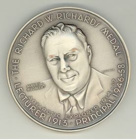 Silver medalion featuring the portrait of a man