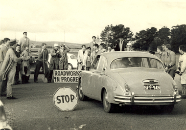 A number of students around a car