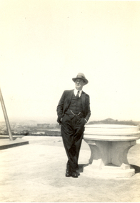Photograph - Black and White, Frank Wright standing next to an architectural feature, 1940's?