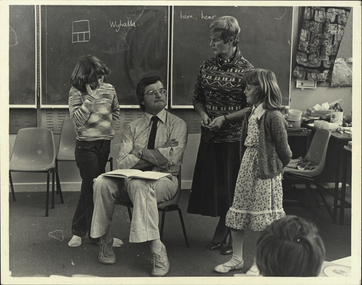 Two adults with two children in a classroom