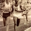 Three men run on a running track,