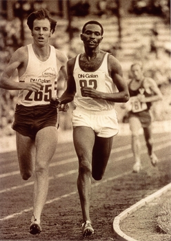 Three men run on a running track,