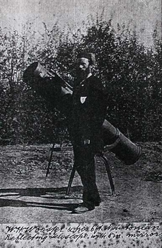 A man stands beside a telescope