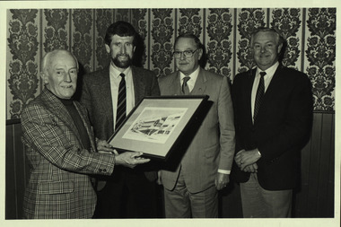 Photograph - black and white, Morgan B. John is presented with an artwork of the Ballarat School of Mines M.B. John Building