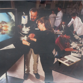 Photograph, SMB students using microscopes with John Jelbart, not dated