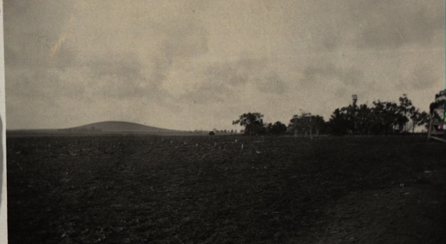 A farm with a hill in the background