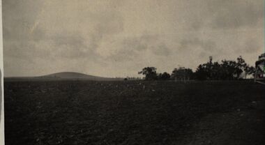 A farm with a hill in the background