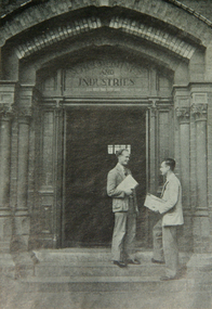 Two men on  the stairs of a doorway