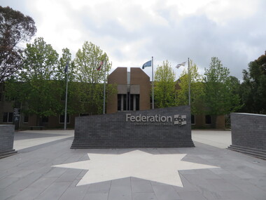 The Federation Universitu graduation wall with a white star on the ground