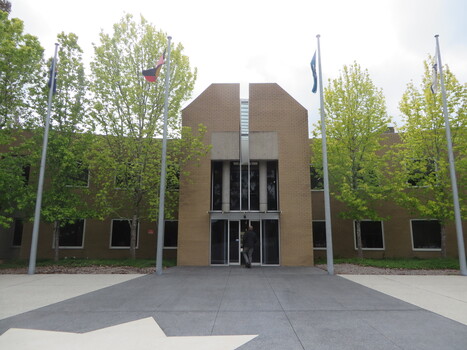 Brown brick building with 4 flagpoles
