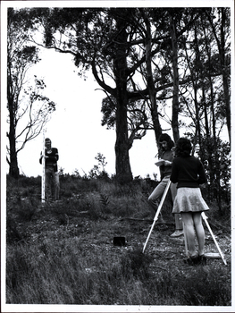 A women and two men survey a bush block