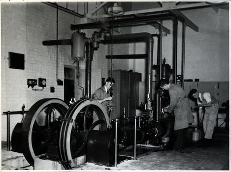 Three men work on a steam engine at the Ballarat School of Mines