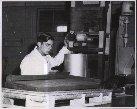 A metallurgy student in white lab coat