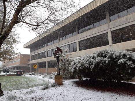 Snow in a courtyard featuring the E.J. Barker Library