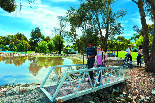 Students cross a bridge in an open space