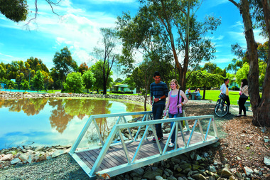 Students cross a bridge in an open space