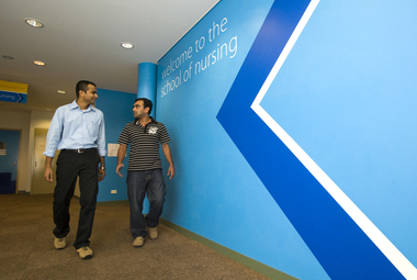 Two men walk in the Nirsing School