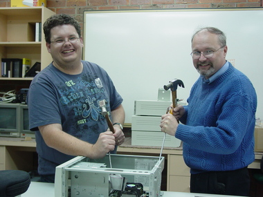 Two men work on a computer