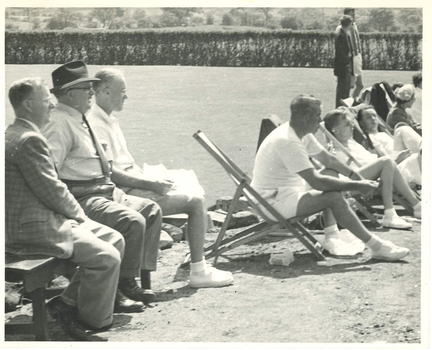tennis players and spectators watch a game