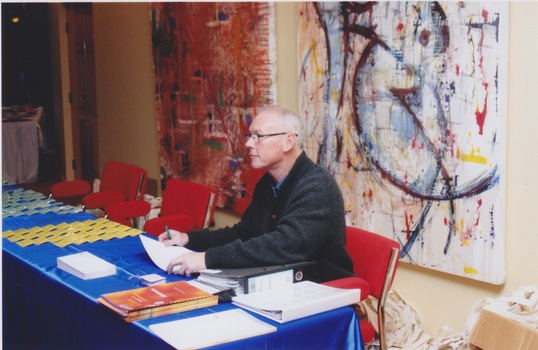 A man sits behind a desk