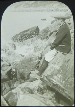 Boy on rocks beside the sea