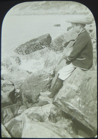 Boy on rocks beside the sea