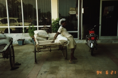 Photograph - Photograph - Colour, VIOSH: Man carrying heavy sack - method used. Taken by Derek Viner in June 1994