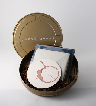Bronze-gold metal film canister containing invitation coaster, event poster, CD Rom catalogue of student work and coffee beans.