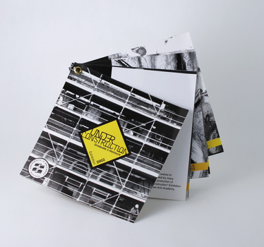 Eight single-sided pages printed black and yellow, bound top left with metal paper fastener. 