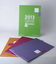 Green A5 volume standing, orange, grape and purple volumes fanned flat.
