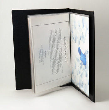 Opened black textured binder reveals plastic sleeves, holding student postcards.