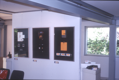 Exhibition space featuring three frames of student work, and plinth displaying student packaging