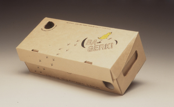 Cardboard packaging for eggs, black text and graphics and yellow chick