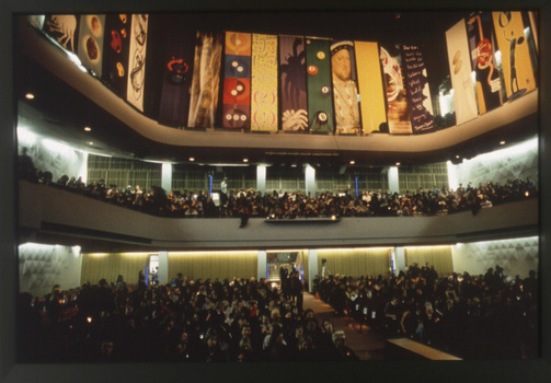 Image of full auditorium with designed banners hanging from balconies