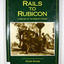 Hardcover. Green dust cover. Front cover photograph is Krauss 0-4-OWT, builder's No. 2459 of 1891, takes water at the western end of Rubicon Lane in 1934. Driver Bob Rees attends to his engine while brakeman Hayden looks on. End papers show a photograph of a man standing besides a timber railway trolley holding onto the brake lever. There is a group of men, some sitting and some standing, on piles of cut timber under a large, open shed in the background.There are also some small, timber, tent like structures standing next to the railway tracks. There is a forest in the far background. Written in white is the line "Mr Clarke & Kidd's Sawmill". 