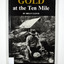 Paperback. Black cover. Front cover has a photograph of a man gold panning with his dog in a river. In the background is an old wooden house.